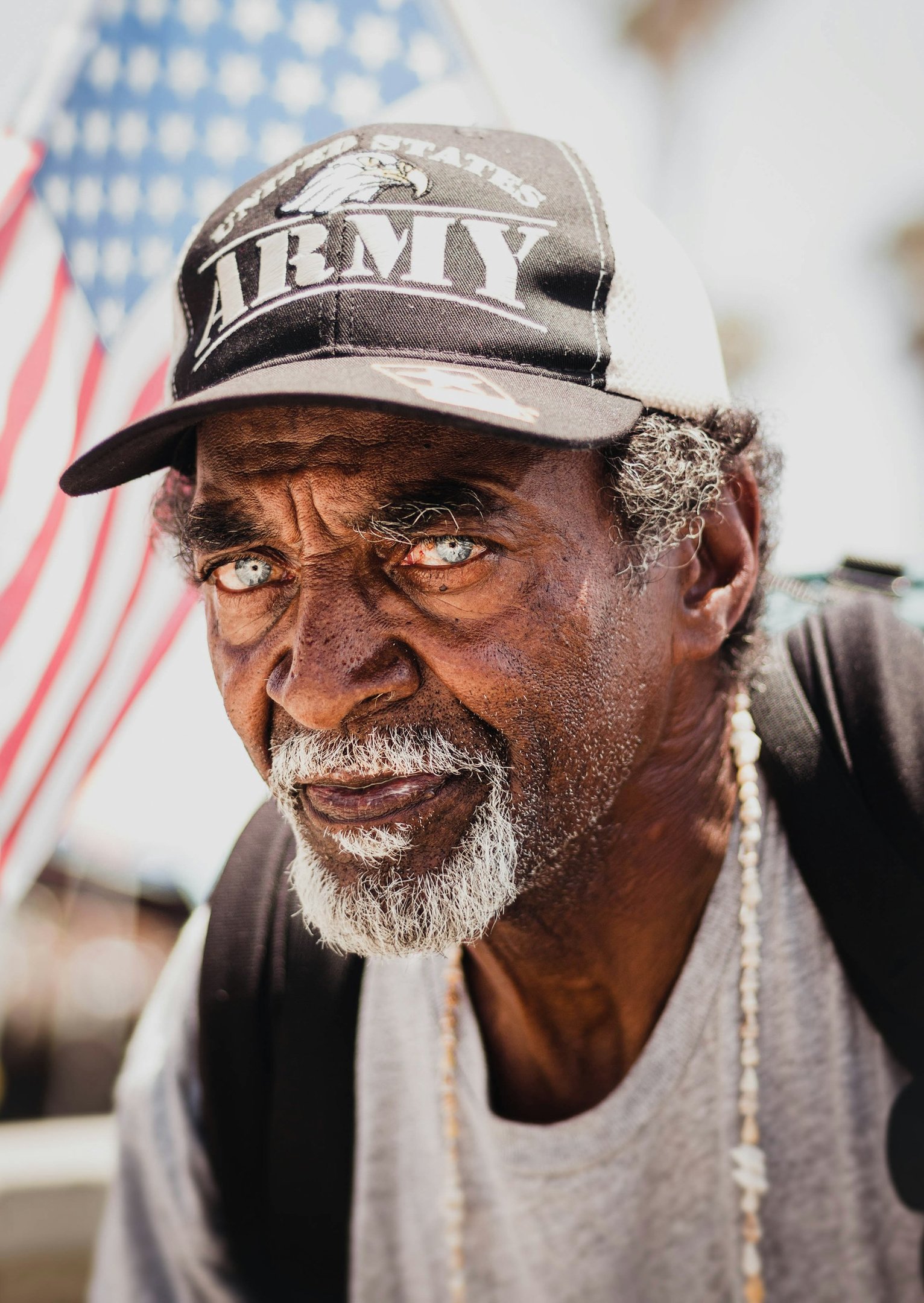 Senior veteran smiling at home with an American flag