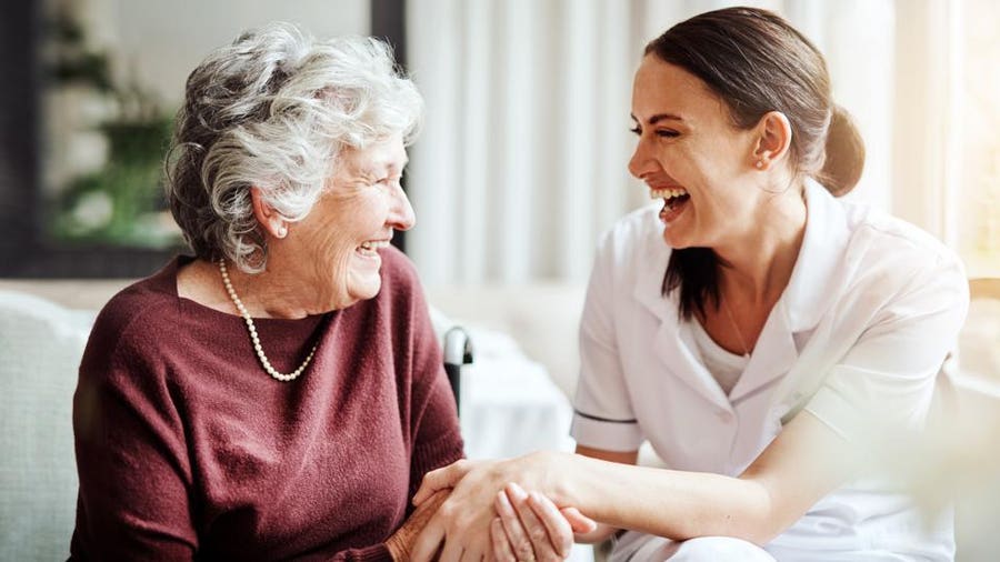 Caregiver and senior sharing a laugh while playing a game together