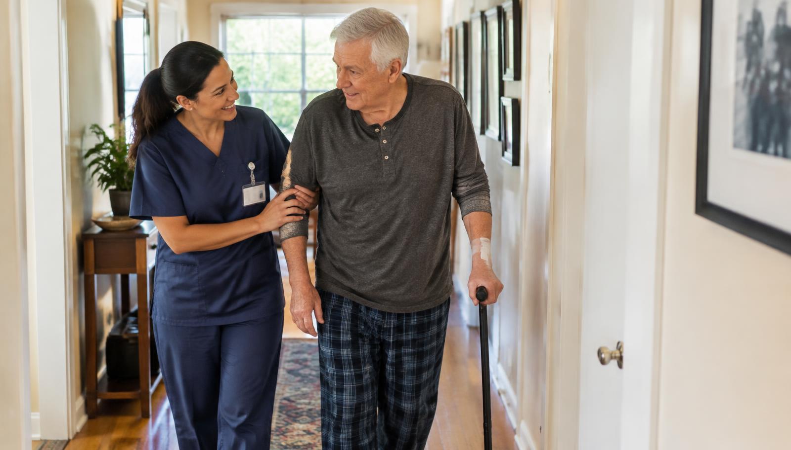 Caregiver supporting a senior man walking with a cane at home